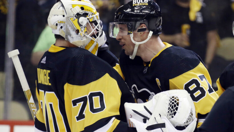 Pittsburgh Penguins goaltender Louis Domingue celebrates with center Sidney Crosby