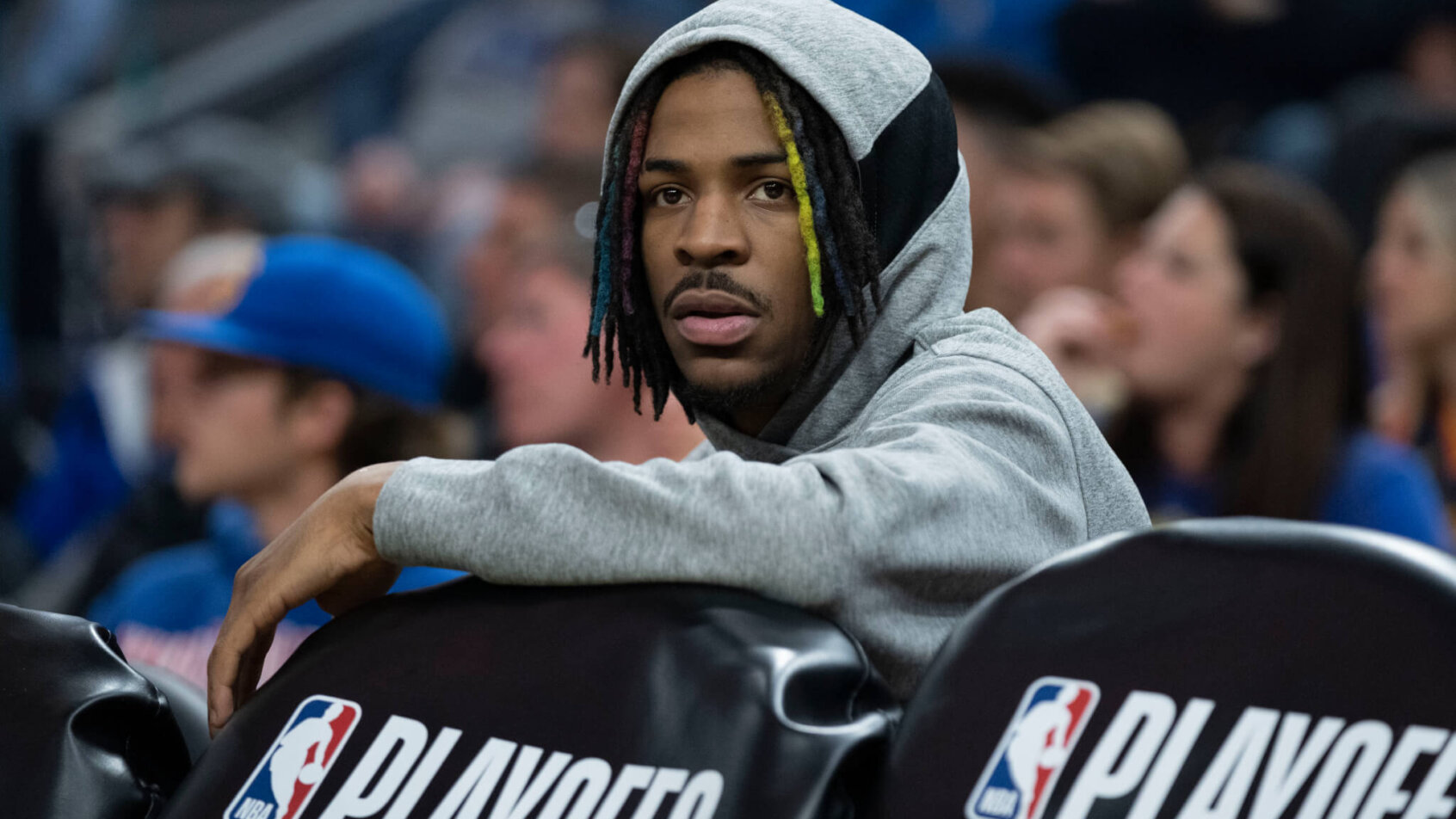 Ja Morant wearing hood sitting behind bench