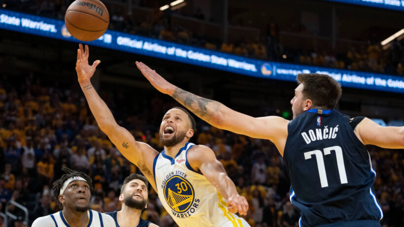 Golden State Warriors guard Stephen Curry shooting the ball while Dallas Mavericks guard Luka Doncic defends