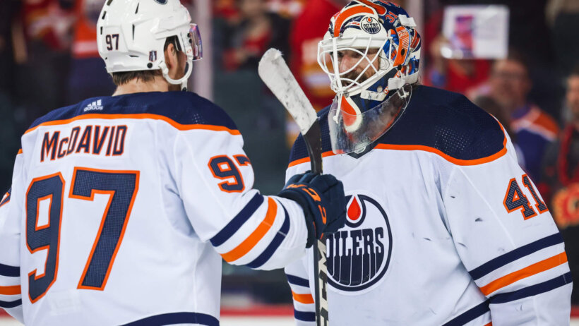 Edmonton Oilers goaltender Mike Smith and center Connor McDavid celebrating a win.
