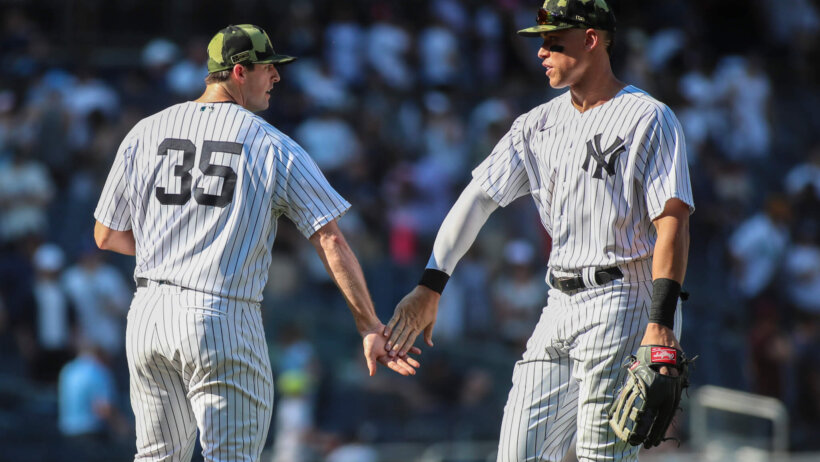 New York Yankees relief pitcher Clay Holmes high-fiving outfielder Aaron Judge