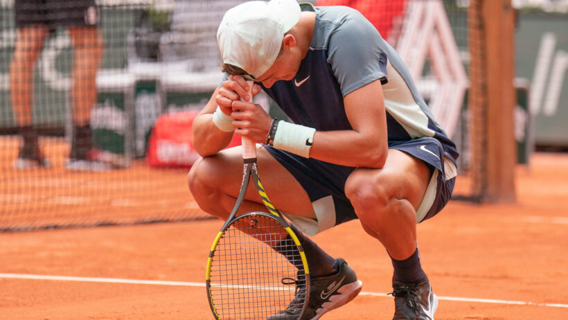 Holger Rune squatting down in celebration