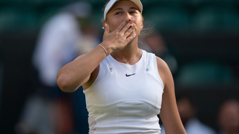 Amanda Anisimova blowing a kiss to the crowd after a tennis match.