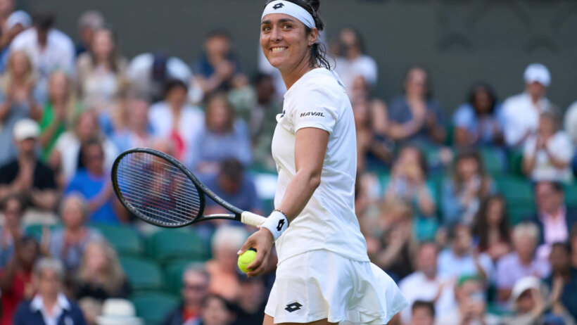 Ons Jabeur smiling during a match at Wimbledon.
