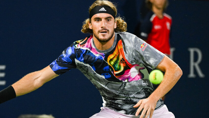 Stefanos Tsitsipas hitting a forehand shot back.