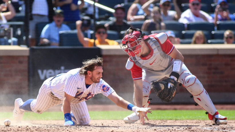 Mets second baseman Jeff McNeil scores before Phillies catcher J.T. Realmuto is able to apply the tag