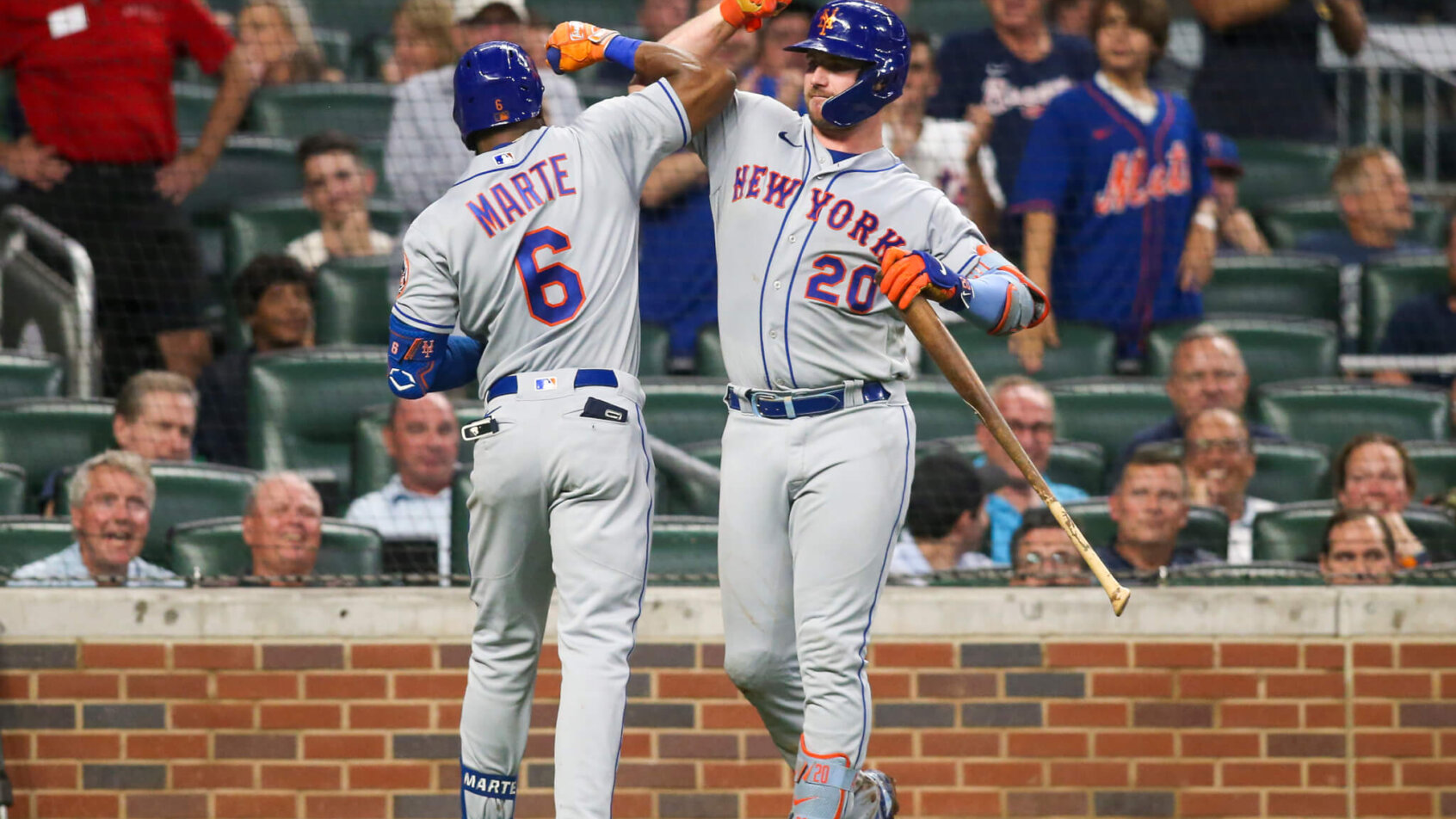 Mets players celebrating after scoring a run.