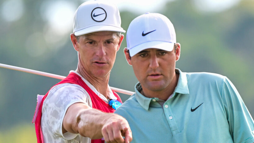 Scottie Scheffler gets a line from his caddie
