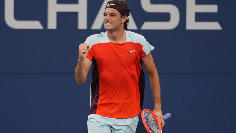 Taylor Fritz celebrating with a fist pump as he wins a point during a tennis match.