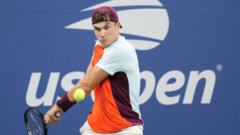 Jack Draper hitting a backhanded shot during a tennis match at the US Open.