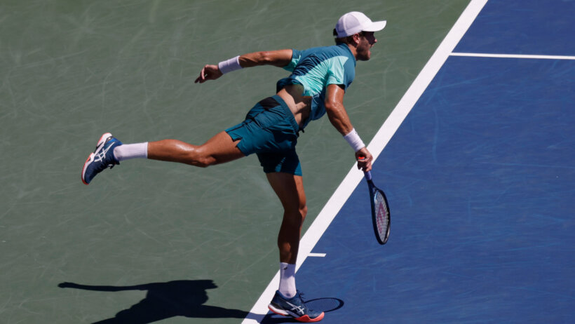 Borna Coric hitting a serve during a tennis match.