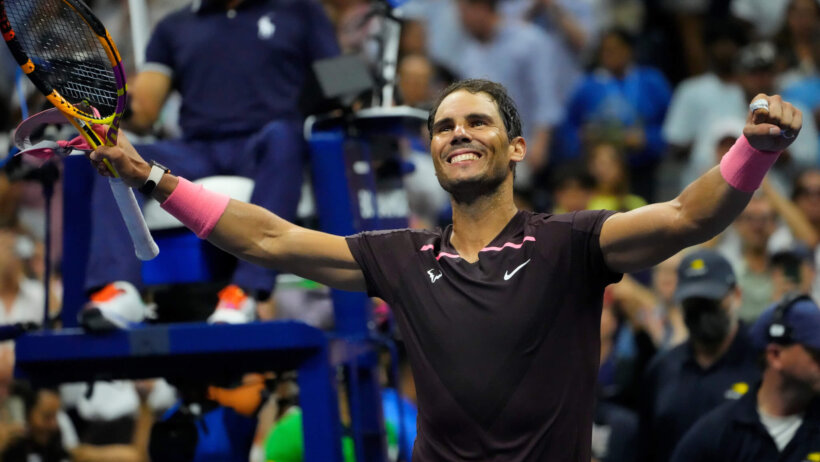 Rafael Nadal celebrating with his arms up after a match.
