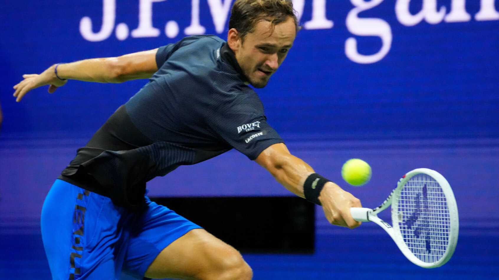 Daniil Medvedev hitting a backhand during a tennis match.