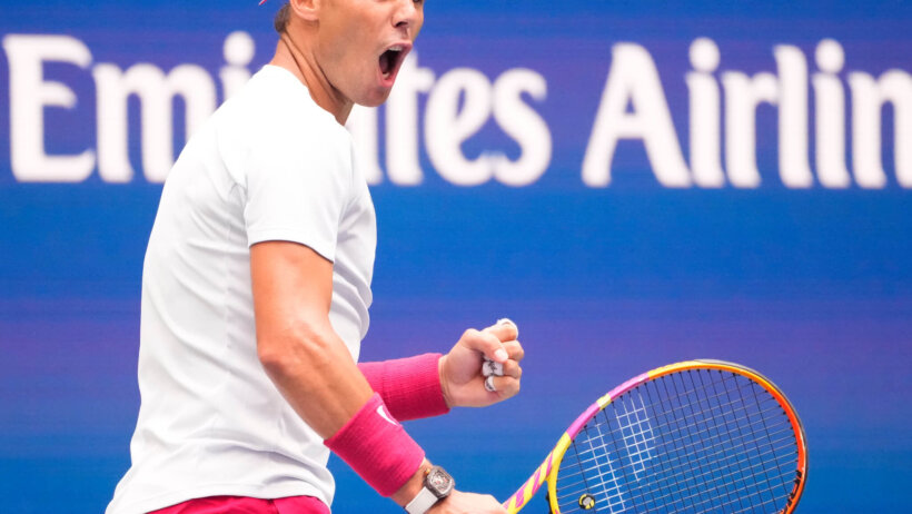 Rafael Nadal reacting with a fist pump during a tennis match.