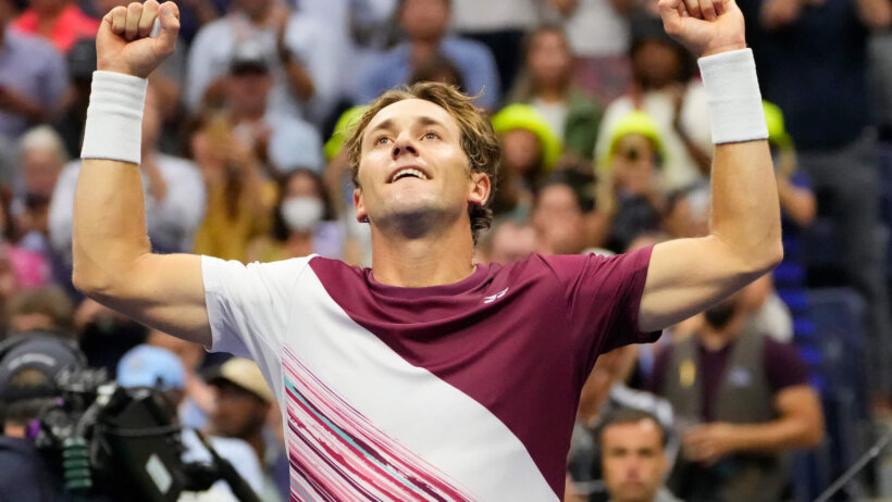 Casper Ruud celebrating with his hands in the air.