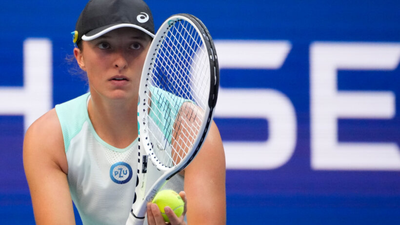 Iga Swiatek staring down her opponent before serving the ball.