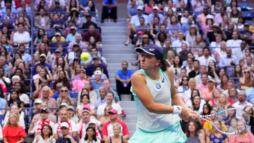 Iga Swiatek hitting a return shot during a tennis match