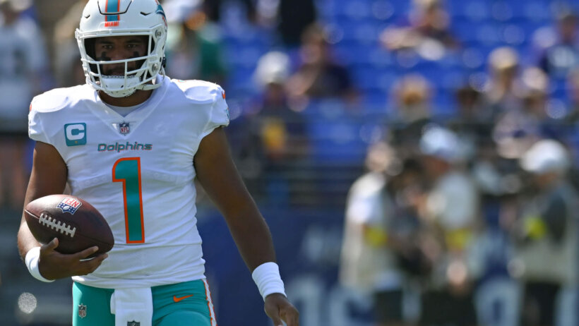 Tua Tagovailoa holding football