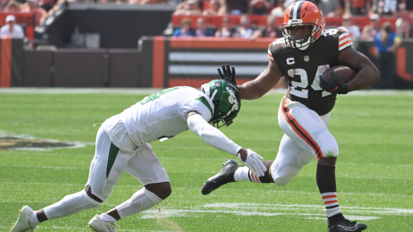 Nick Chubb running, pushing away defender