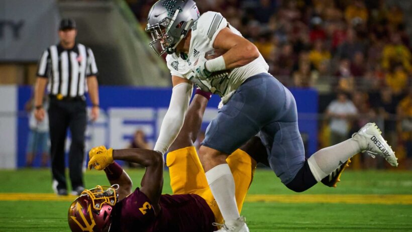 Eastern Michigan Eagles running back Samson Evans pushes opposing player