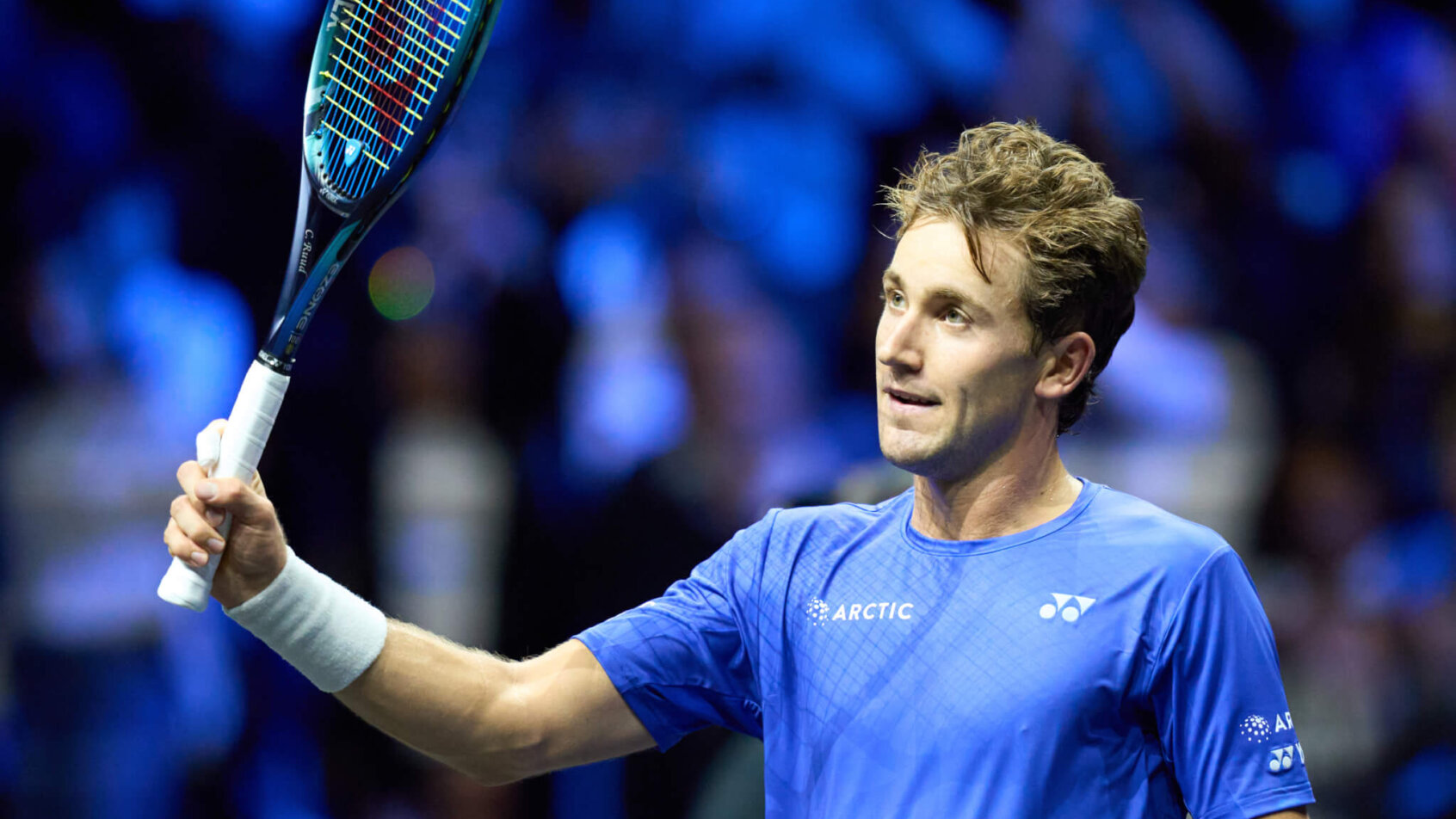 Casper Ruud celebrating with his racket in the air.
