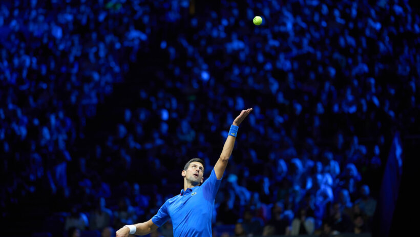 Novak Djokovic hitting a serve during a tennis match.