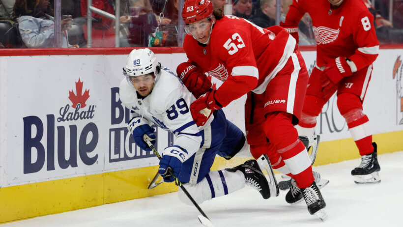 Toronto Maple Leafs left wing Nicholas Robertson and Detroit Red Wings defenseman Moritz Seider battle for the puck