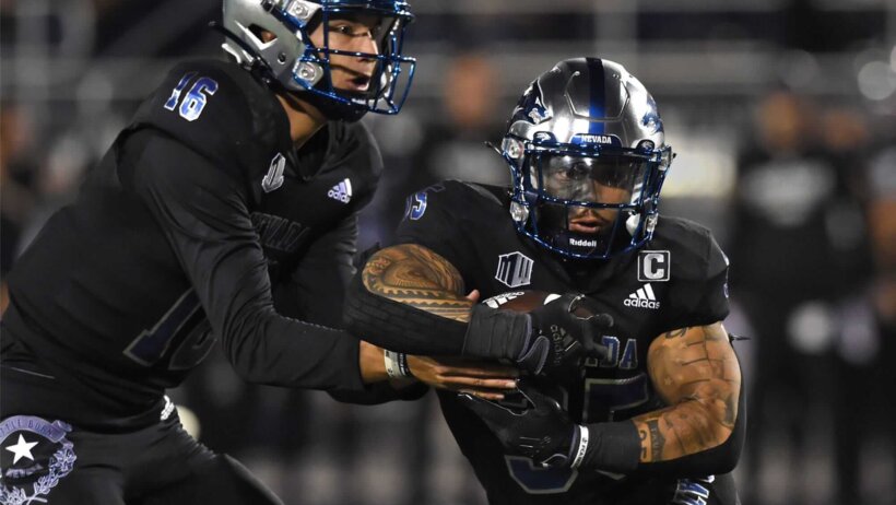 Nevada's Mate Coxs hands the ball off to Toa Taua