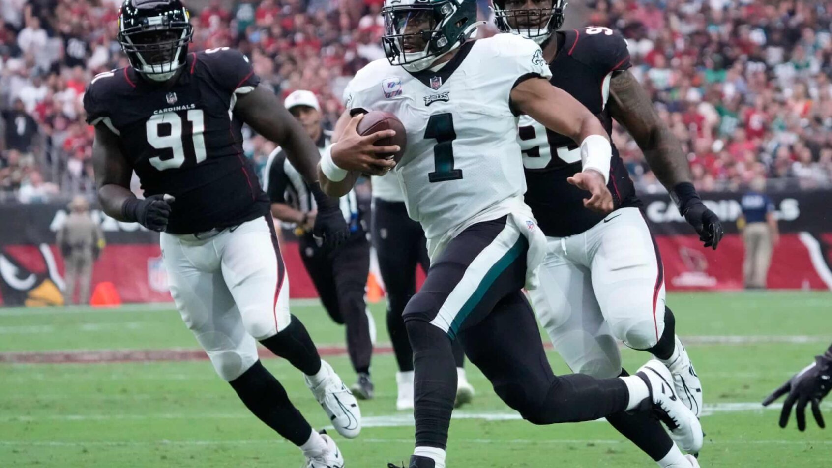 Jalen Hurts running away from defenders