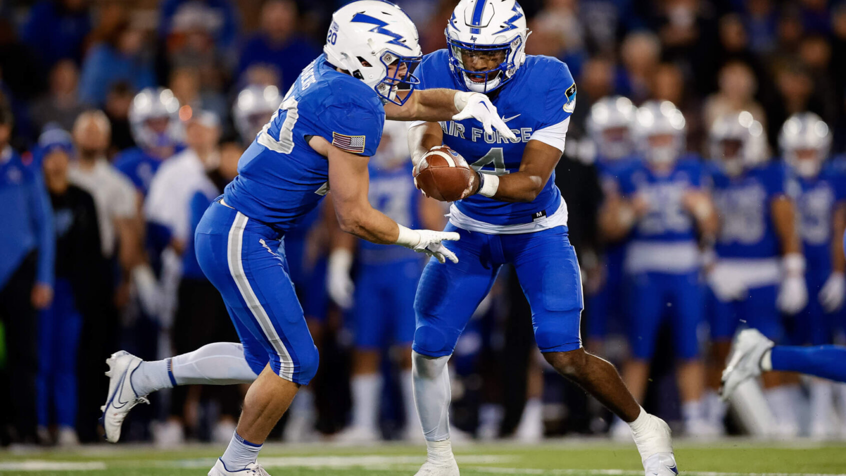Air Force Falcons quarterback Haaziq Daniels hands the ball off to running back Brad Roberts