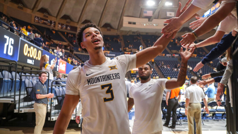 West Virginia Mountaineers forward Tre Mitchell high-fiving fans after a win