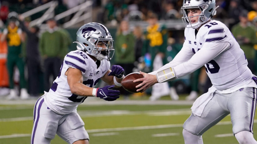 Will Howard hands the ball off to Deuce Vaughn