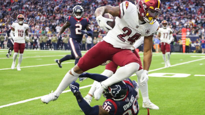 Washington Commanders player breaking tackle