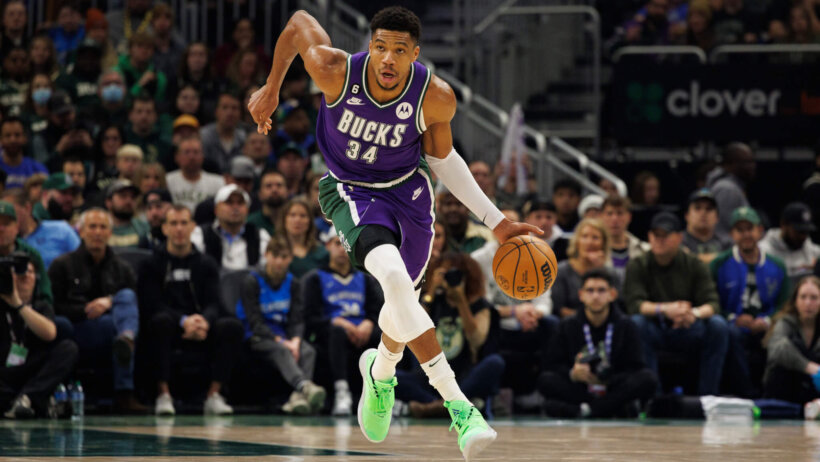 Giannis Antetokounmpo dribbles the ball up court.
