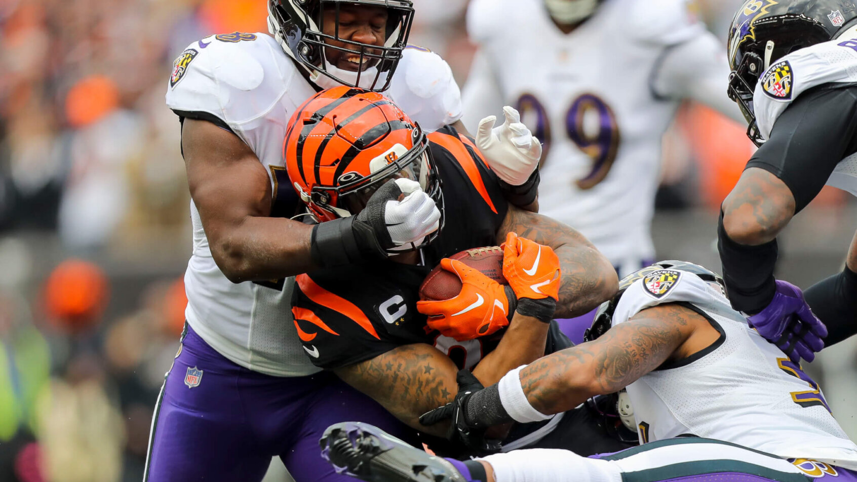 Joe Mixon is wrapped up by multiple Ravens defenders.