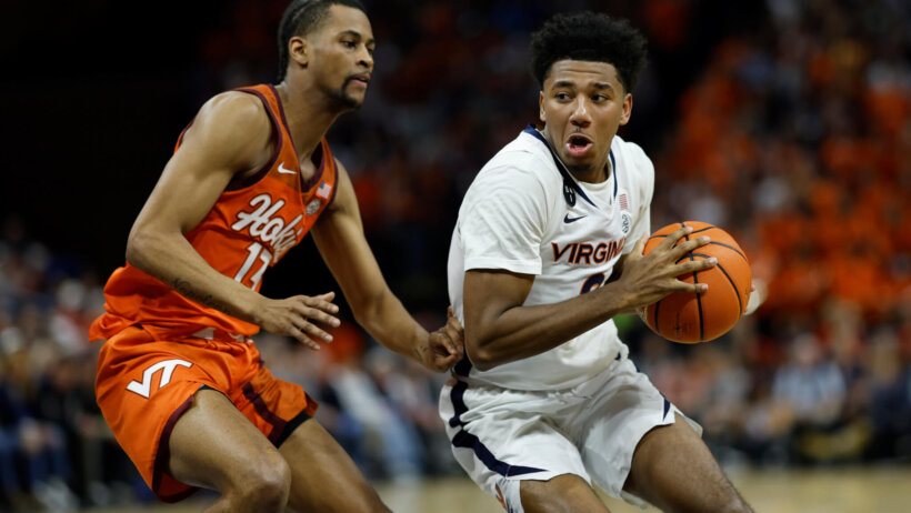 Virginia Cavaliers guard Reece Beekman drives to the basket vs Virginia Tech Hokies guard Darius Maddox.