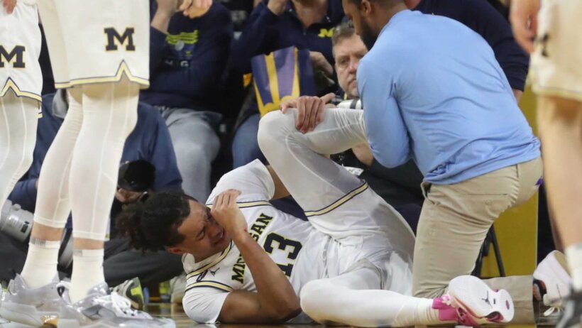 Michigan guard Jett Howard lays on the floor injured