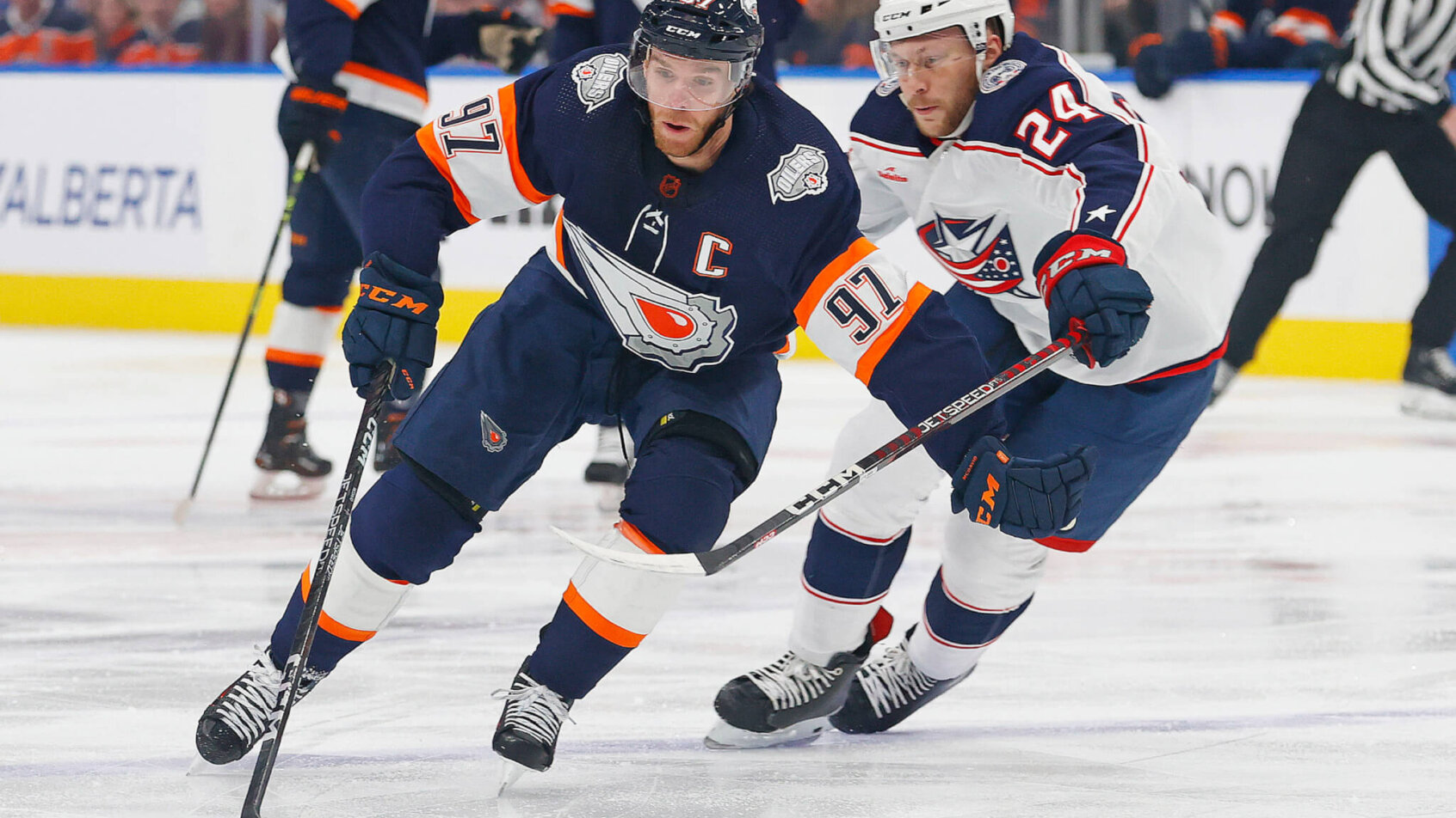 Edmonton Oilers forward Connor McDavid carries the puck around Columbus Blue Jackets forward Mathieu Olivier