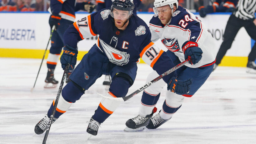Edmonton Oilers forward Connor McDavid carries the puck around Columbus Blue Jackets forward Mathieu Olivier