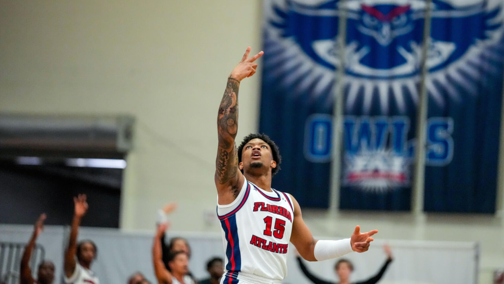 Alijah Martin arm up with peace sign after hitting 3