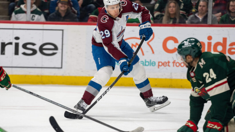 Colorado Avalanche center Nathan MacKinnon shoots past Minnesota Wild defenseman Matt Dumba
