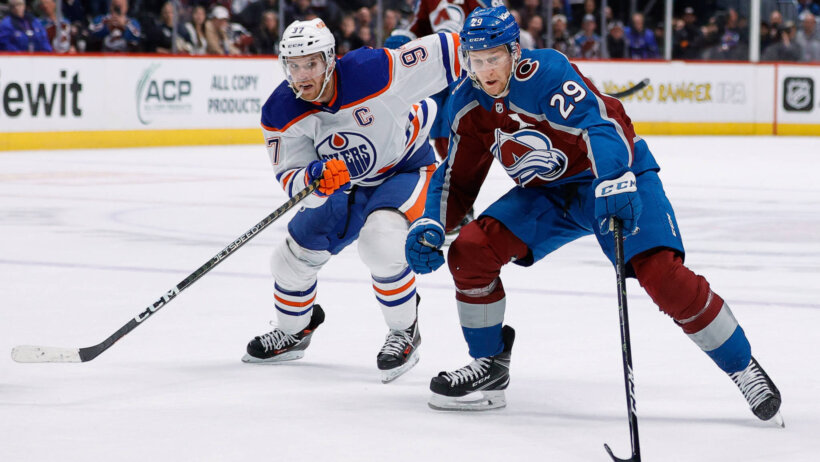Colorado Avalanche center Nathan MacKinnon controls the puck ahead of Edmonton Oilers center Connor McDavid