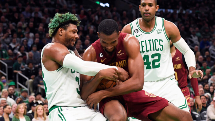 Evan Mobley and Marcus Smart battle for a loose ball.