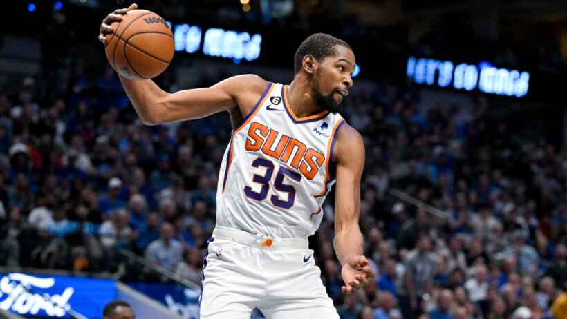 Kevin Durant holding the ball out with one hand