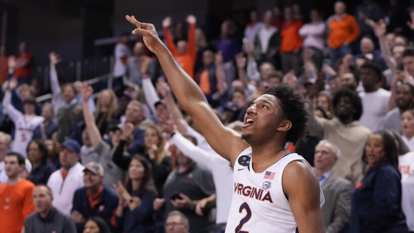 Virginia Cavaliers guard Reece Beekman making the three-point symbol