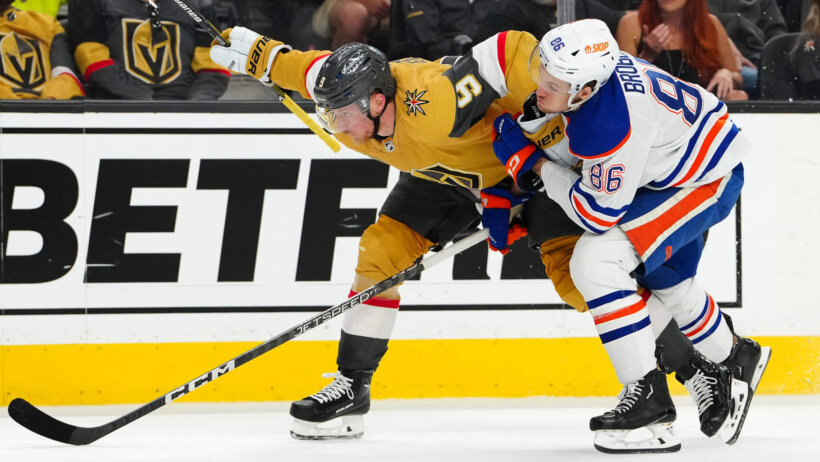 Vegas Golden Knights center Jack Eichel is held by Edmonton Oilers defenseman Philip Broberg