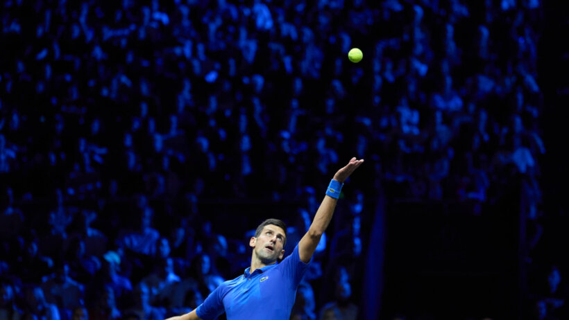 Novak Djokovic serving a ball during a tennis match.