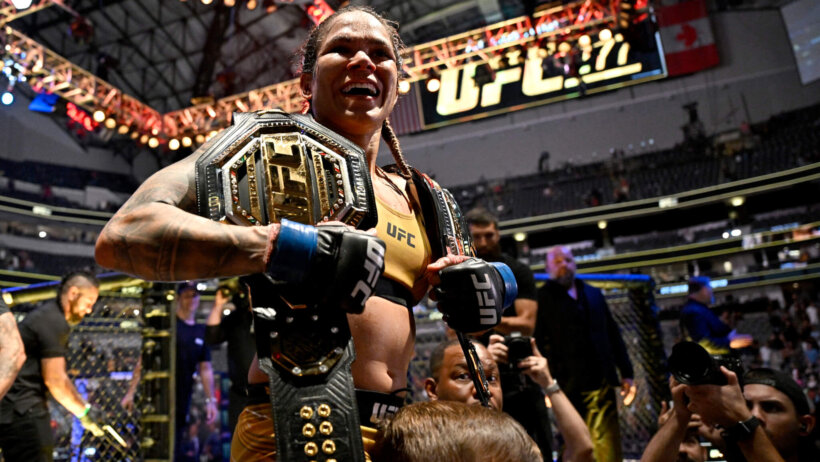 Amanda Nunes holding her title belts