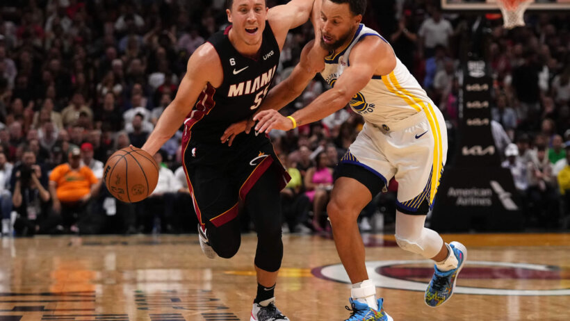 Miami Heat guard Duncan Robinson drives around Golden State Warriors guard Stephen Curry