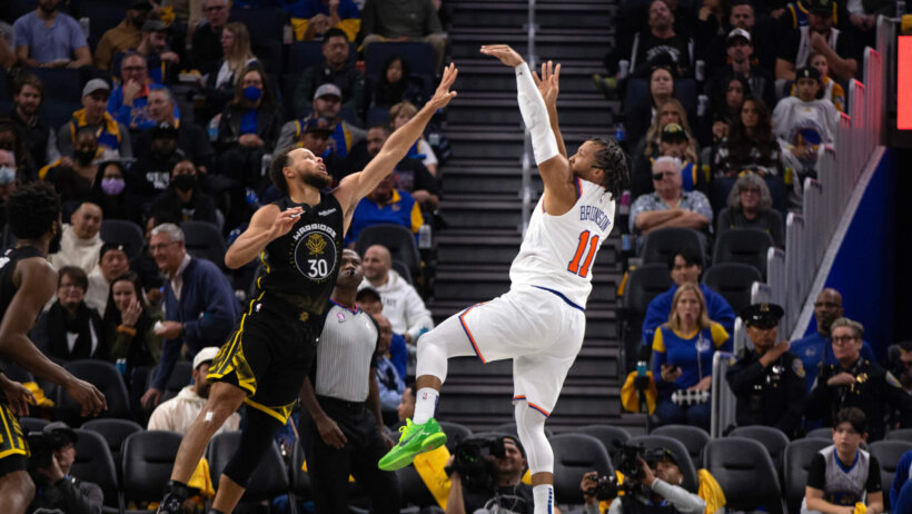New York Knicks guard Jalen Brunson shoots over Golden State Warriors guard Stephen Curry
